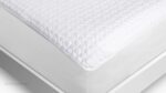Luxurious white quilted mattress topper for optimal comfort and temperature regulation.