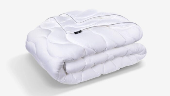 Cozy white quilted blanket with zipper, perfect for warmth and versatile home décor.