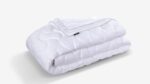 Plush quilted white comforter offers warmth, versatility, and elegance for any bedroom decor.