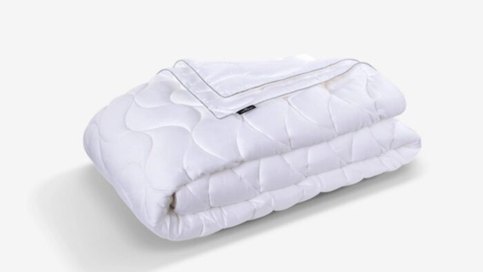 Plush quilted white comforter offers warmth, versatility, and elegance for any bedroom decor.