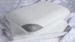 Ergonomic Rise pillows in white with mint trim on textured bedding for restful sleep.