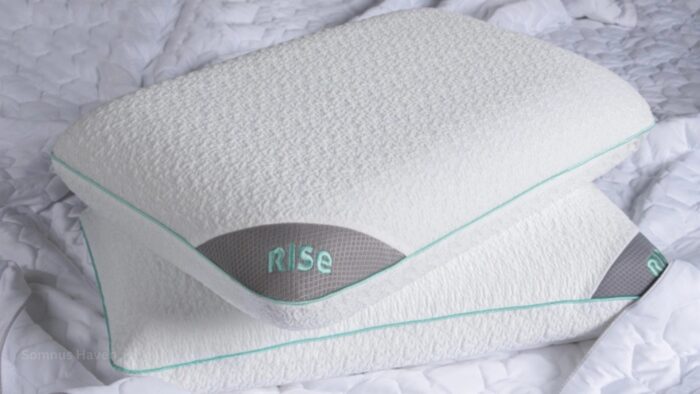 Ergonomic Rise pillows in white with mint trim on textured bedding for restful sleep.