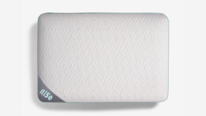 White ergonomic pillow with Rise branding, featuring rounded edges and breathable fabric for comfort.