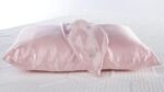 Luxurious satin pink pillow with elegant draped fabric, highlighting sophistication and comfort.
