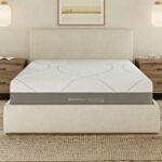 Modern bedroom with plush bed, warm lighting, and serene decor featuring natural elements.