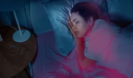 Tranquil sleep scene with woman dreaming in softly lit bedroom, suggesting calm and introspection.