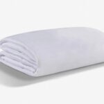Soft white blanket with minimalist design, offering warmth and comfort for any decor.