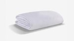 Soft white blanket with minimalist design, offering warmth and comfort for any decor.