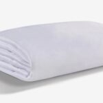 Plush white blanket with soft texture on a neutral background, ideal for home aesthetics.