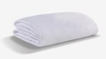 Plush white blanket with soft texture on a neutral background, ideal for home aesthetics.