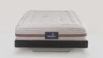 Luxurious Magniflex mattress with tufted design on sleek black frame for modern comfort.