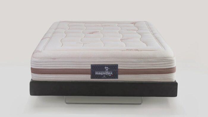 Luxurious Magniflex mattress with tufted design on sleek black frame for modern comfort.