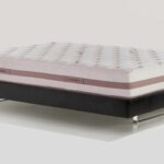 Luxury tufted mattress on sleek frame enhances modern bedroom decor.