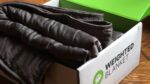 Brown weighted blanket in box, featuring owl logo, on warm wooden surface for cozy comfort.