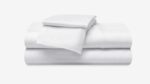 White bedding set with fitted sheet, flat sheet, and pillowcase for serene bedroom aesthetics.