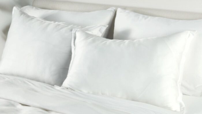 Minimalist white bedding set exuding luxury and tranquility for peaceful relaxation.