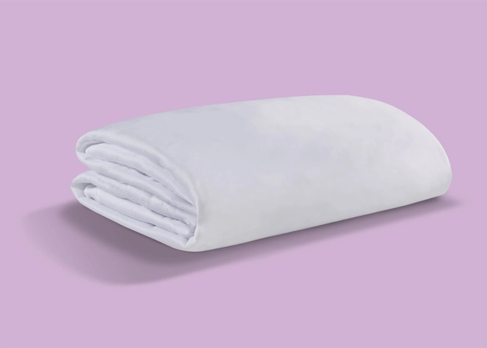 Pristine white blanket on soft pink background, highlighting quality and inviting tranquility.
