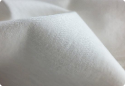 Luxurious soft white fabric texture with high thread count and elegant folds.