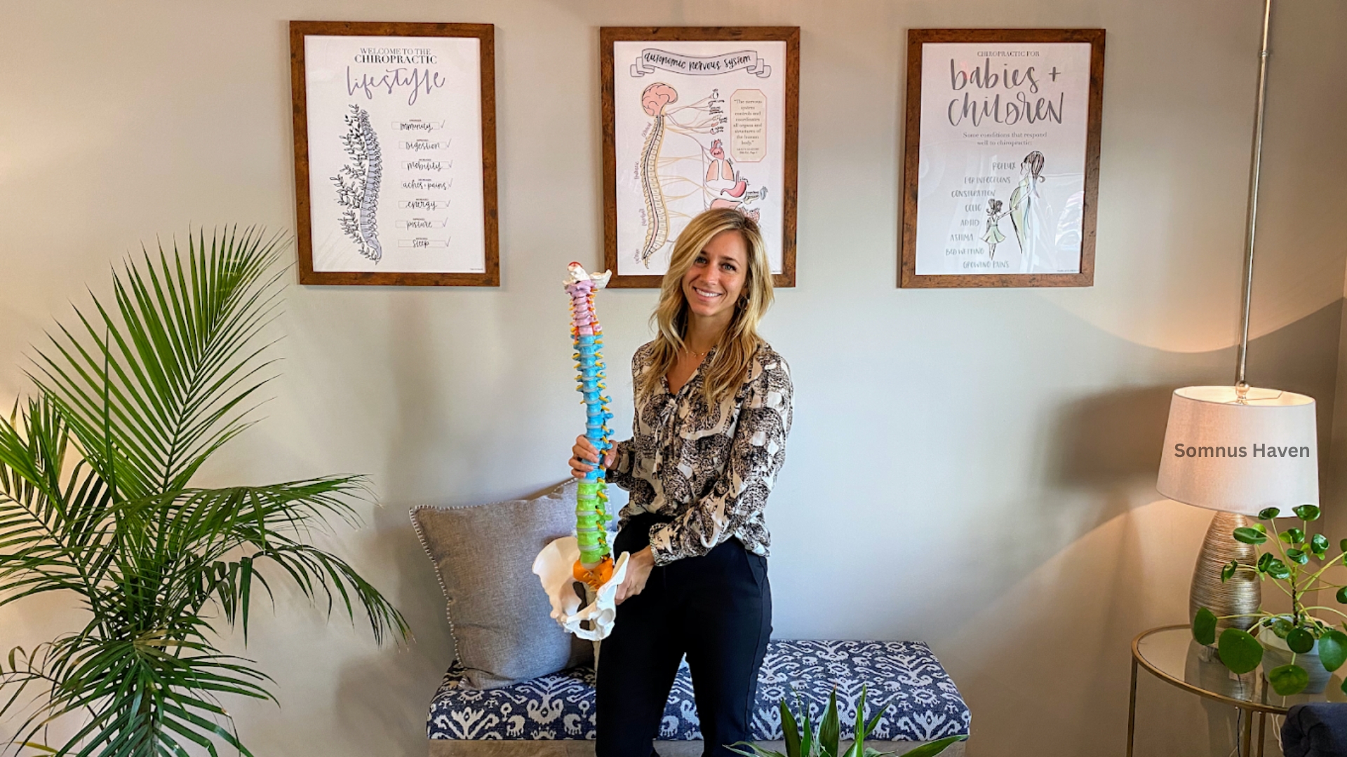 Woman holding spine model in cozy, professional health consultation setting.